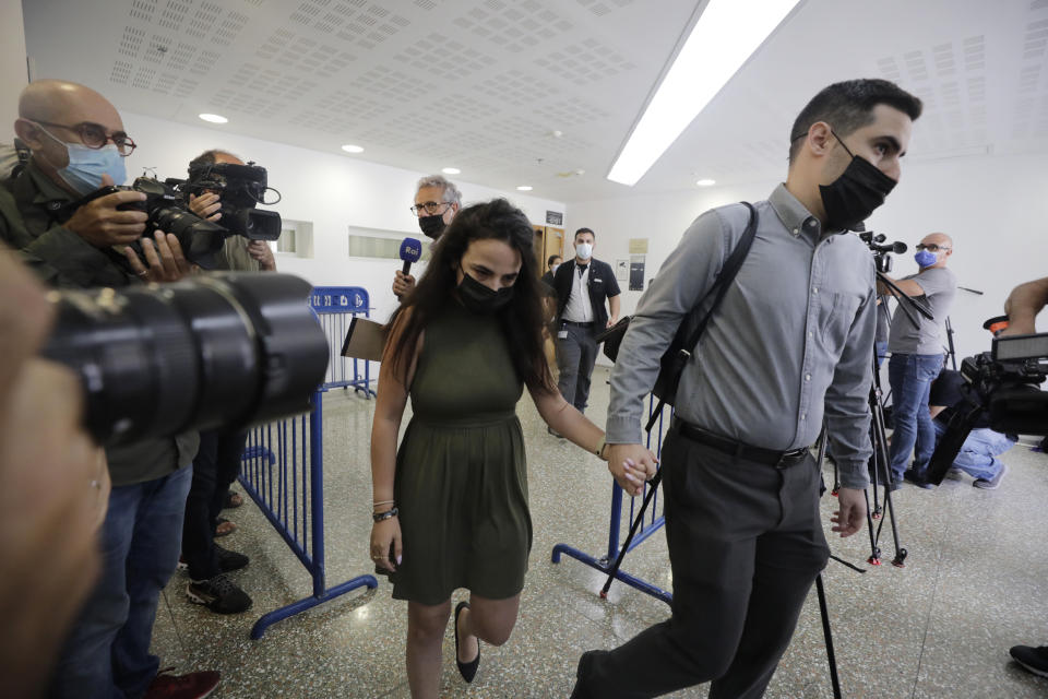 Gali Peleg, center, maternal aunt of Eitan Biran, who survived a cable car crash in Italy that killed his immediate family, leaves court in Tel Aviv on Thursday, Sept. 23, 2021 after a hearing in the alleged kidnapping of her nephew. The boy's parents and younger sibling were among 14 killed in May when a cable car slammed into a mountainside in northern Italy. He is now the focus of a custody battle between his maternal grandparents in Israel and his paternal relatives in Italy. (AP Photo/Sebastian Scheiner)