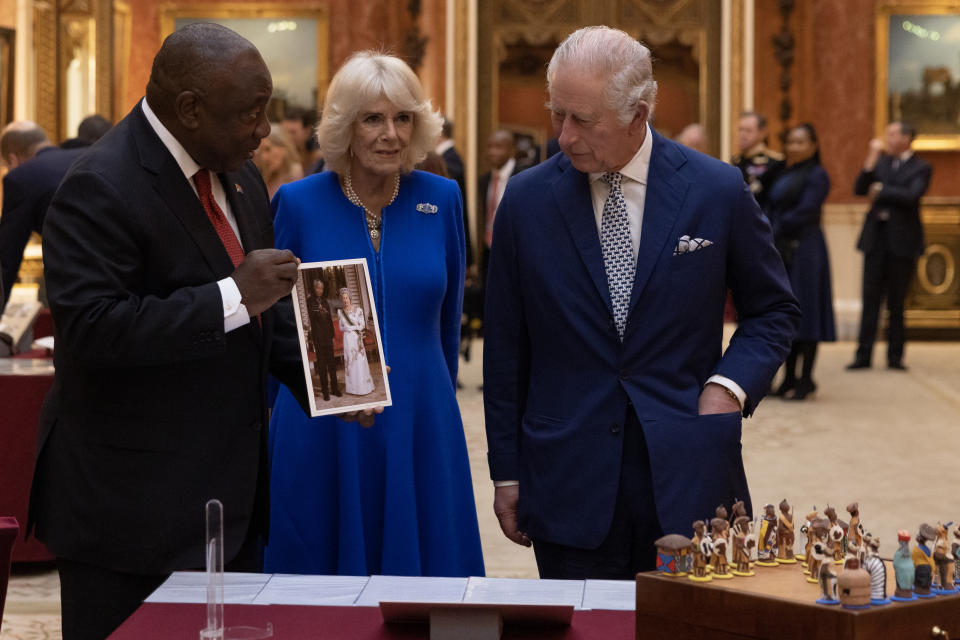 (left to right) President Cyril Ramaphosa of South Africa, the Queen Consort and King Charles III view a display of South African items from the Royal Collection, a photograph of President Mandela and Queen Elizabeth II, at Buckingham Palace, London, during the State Visit to the UK by the South African president. Picture date: Tuesday November 22, 2022.