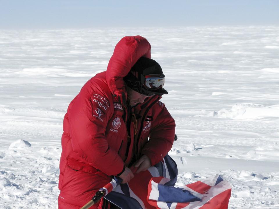 Prince Harry rolls the Union Jack on the first day of the Virgin Money South Pole Allied Challenge 2013 expedition in Antarctica