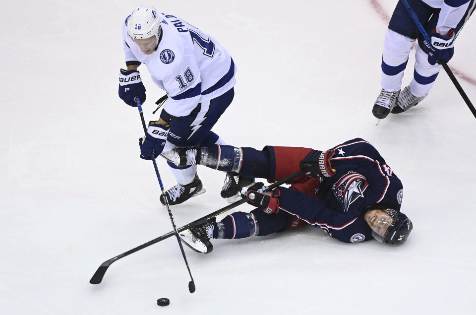 Columbus Blue Jackets center Gustav Nyquist (14) is sent to the ice by Tampa Bay Lightning left wing Ondrej Palat (18) during the second period of Game 3 of an NHL hockey first-round playoff series, Saturday, Aug. 15, 2020, in Toronto. (Nathan Denette/The Canadian Press via AP)