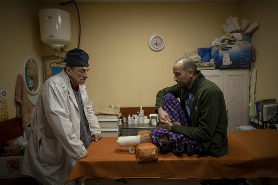 Ukrainian doctor Yurii Kuznetsov speaks to land mine victim Oleksandr Kolisnyk at the hospital in Izium, Ukraine, Sunday, Feb. 18, 2023. Russian attacks have devastated Ukraine's health care system, raining down explosions upon hospitals and ambulances at a rate of nearly two a day for the past year, according to a study that attempted to document each strike.(AP Photo/Vadim Ghirda)