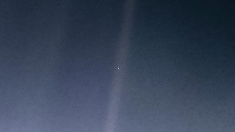 The “Pale Blue Dot” image taken by Voyager 1 spacecraft in 1990, showing Earth as a tiny bright speck surrounded by darkness.