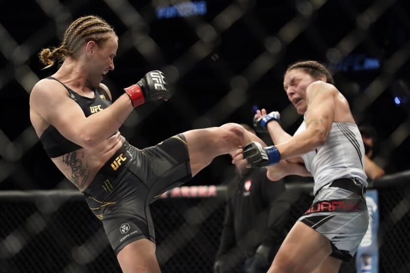 Valentina Shevchenko, left, throws a kick to the body against Lauren Murphy during a women's flyweight mixed martial arts title bout at UFC 266, Saturday, Sept. 25, 2021, in Las Vegas. (AP Photo/John Locher)