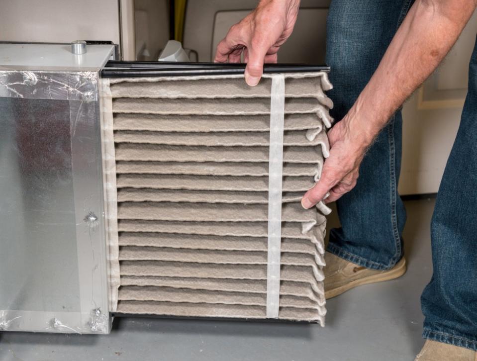 Man pulling out dirty hvac filter