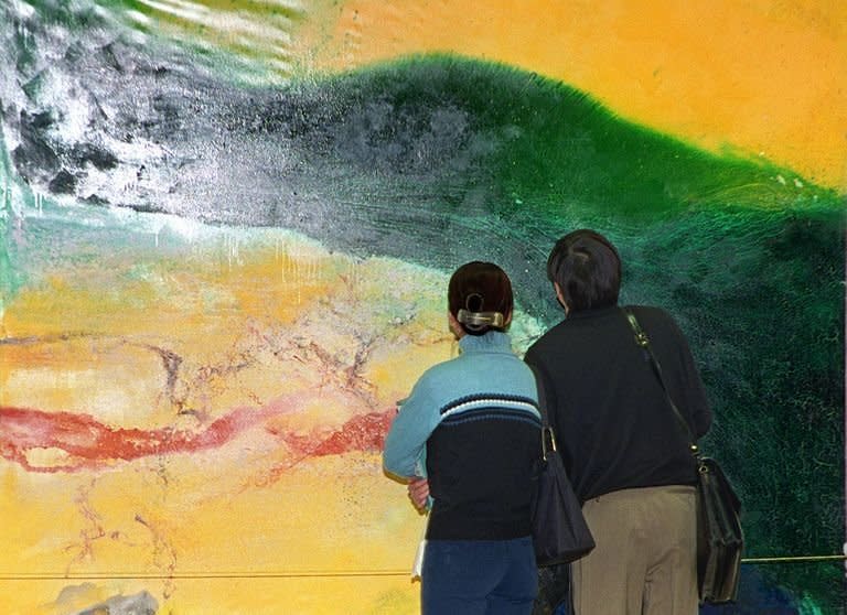 Visitors look at an abstract oil painting by Zao Wou-ki at an exhibition in Beijing, March 4, 1999. Zao, a significant figure in 20th-century Chinese art, died Tuesday at his home in Switzerland aged 93, Marc Bonnant, a lawyer for his wife, told AFP