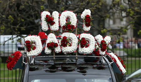 The coffin of PC Keith Palmer, who was killed in the recent Westminster attack, is transported through Carriage Gates at the Palace of Westminster, where it laid overnight, to his funeral at Southwark Cathedral in central London, Britain April 10, 2017. The flowers on top of the hearse spell out 'NO 1 DADDY'. REUTERS/Neil Hall