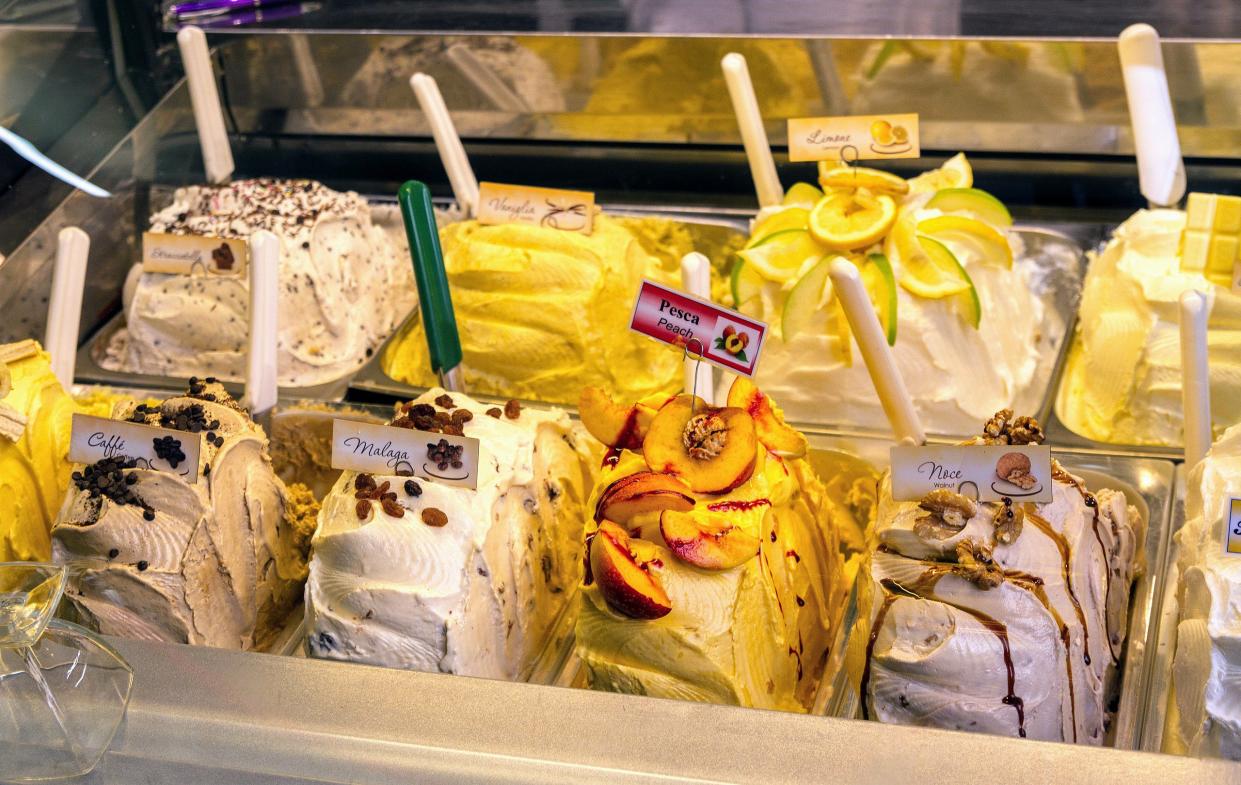 Rows of gelato with flavors including peach, lemon and coffee.