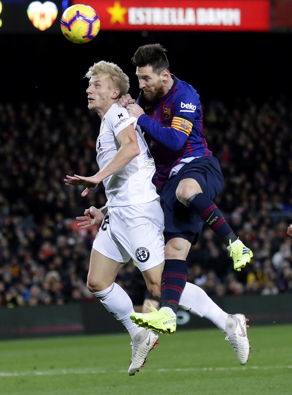 FC Barcelona's Lionel Messi, right, heads for the ball with Valencia's Carlos Soler during the Spanish La Liga soccer match between FC Barcelona and Valencia at the Camp Nou stadium in Barcelona, Spain, Saturday, Feb. 2, 2019. (AP Photo/Manu Fernandez)