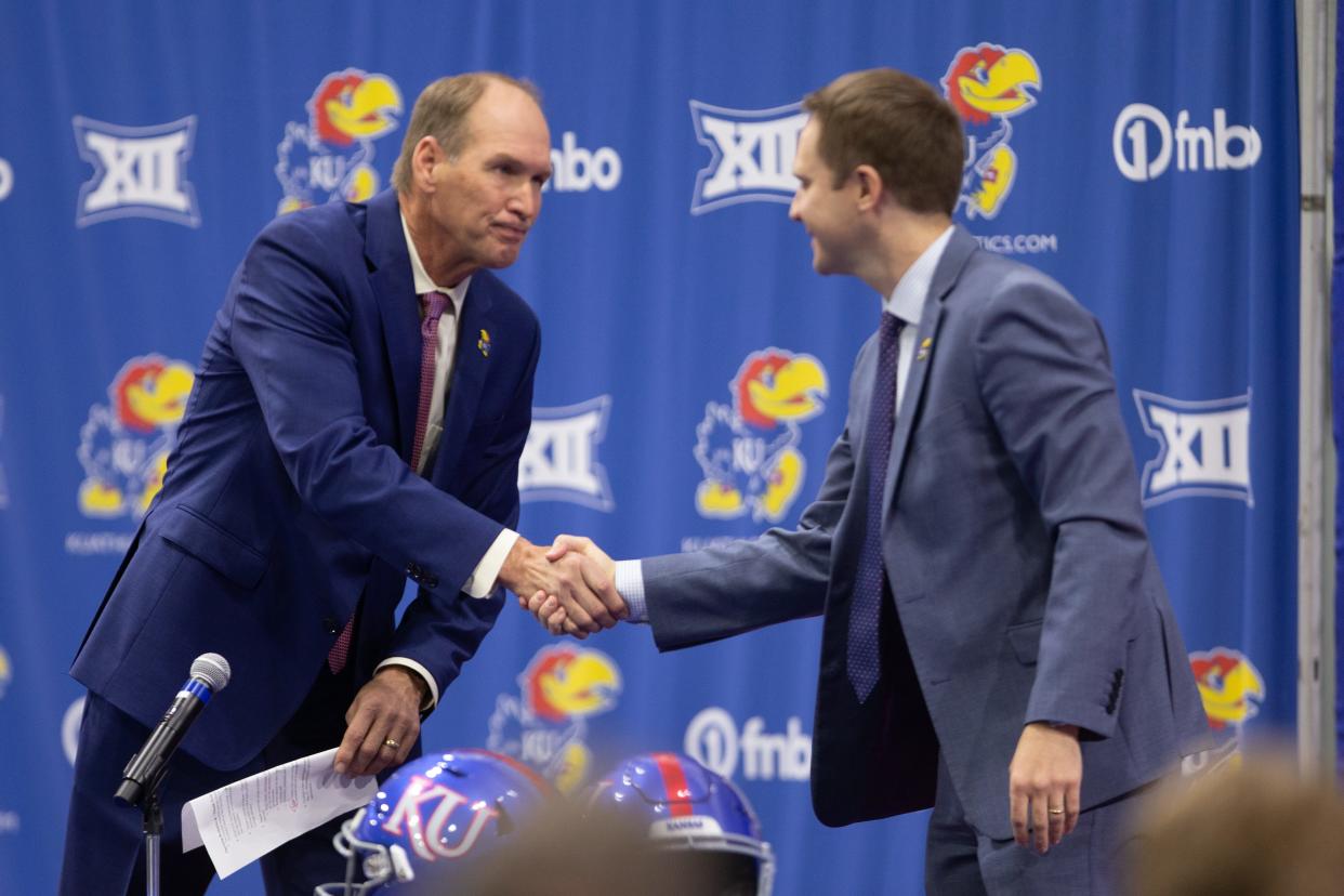 Kansas head football coach Lance Leipold, left, shakes hands with athletics director Travis Goff during a 2021 news conference. Both were in Salina on Tuesday to meet with supporters during a Hawks & Highways stop at The Garage.