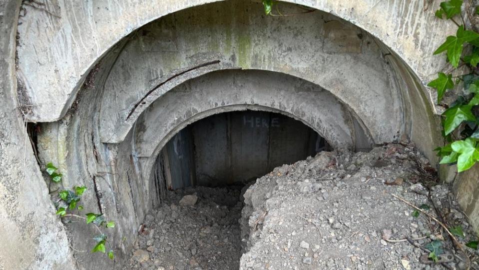 Grey shelter entrance full of stones