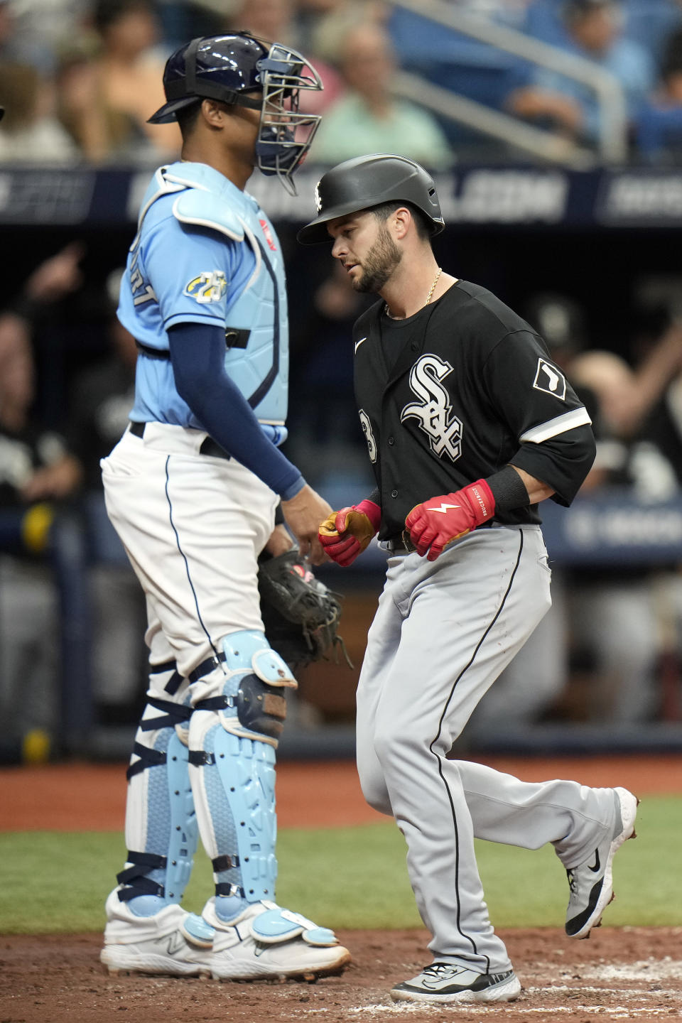 Chicago White Sox's Andrew Benintendi, right, scores in front of Tampa Bay Rays catcher Christian Bethancourt on an RBI double by Eloy Jimenez during the fourth inning of a baseball game Sunday, April 23, 2023, in St. Petersburg, Fla. (AP Photo/Chris O'Meara)