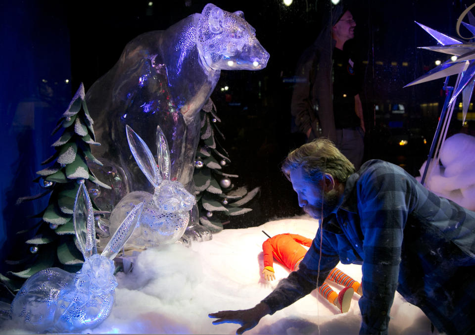 A stylist arranges puffs of imitation snow in a holiday window display at Macy's, Thursday, Nov. 21, 2013 in New York. Forget window shopping, some of Manhattan’s biggest and most storied retailers say their elaborate seasonal window displays are a gift to passers-by. Reimagining every major holiday covered in a slick coating of ice, recreating cozy Christmas-morning scenes and paying homage to a local legend can be an annual labor of love. (AP Photo/Mark Lennihan)