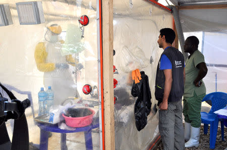 A doctor cares for a patient inside an isolate cube at The Alliance for International Medical Action (ALIMA) treatment center in Beni, North Kivu province of the Democratic Republic of Congo September 6, 2018. Picture taken September 6, 2018. REUTERS/Fiston Mahamba/Files