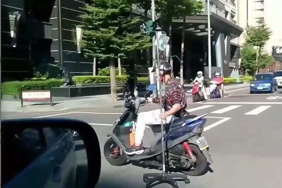 ▲台中阿伯單手騎車邊吊點滴，畫面嚇壞路人。（圖／翻攝自《爆廢公社》）