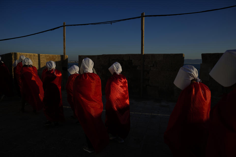 Protesters supporting women's rights dressed as characters from The Handmaid's Tale TV series attend a protest against plans by Prime Minister Benjamin Netanyahu's new government to overhaul the judicial system in the old port of Acre, north Israel, Thursday, March 16, 2023. (AP Photo/Ariel Schalit)