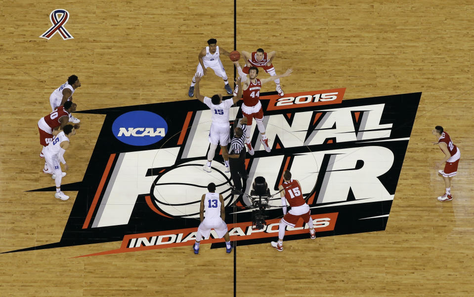 FILE -Duke's Jahlil Okafor (15) and Wisconsin's Frank Kaminsky (44) battle for the ball at the tip off during the first half of the NCAA Final Four college basketball tournament championship game in Indianapolis, in this Monday, April 6, 2015, file photo. The NCAA announced Monday, Jan. 4, 2021, that all 67 men's basketball tournament games including the Final Four will be played entirely in Indiana in a bid to keep the marquee event from being called off for a second consecutive year because of the coronavirus pandemic.(AP Photo/David J. Phillip, File)