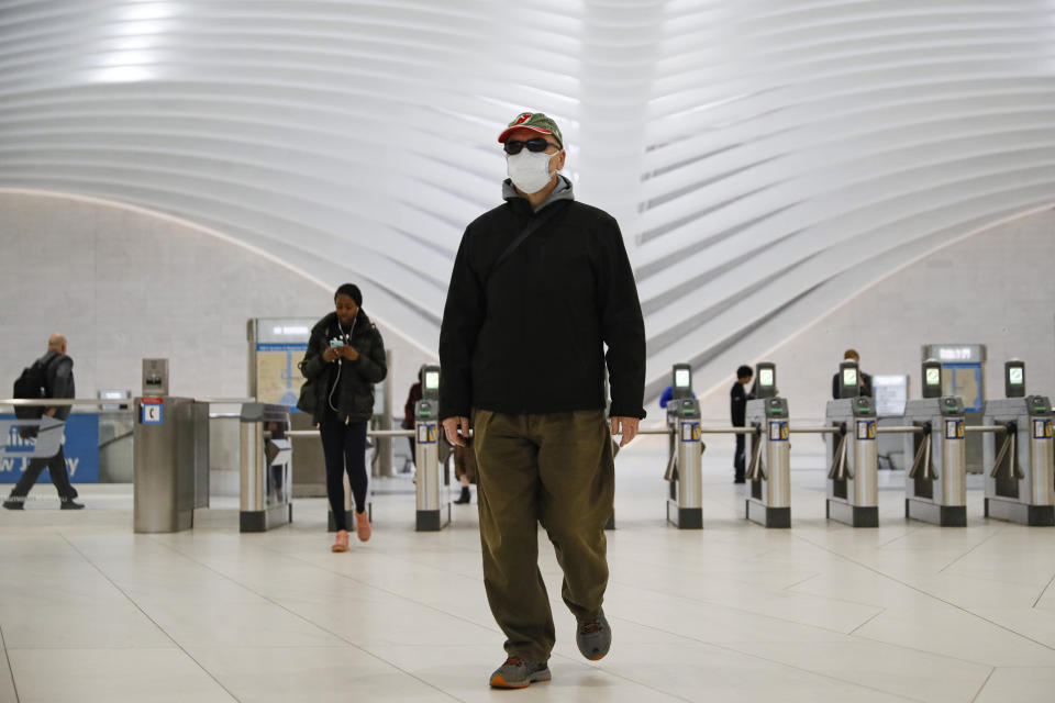 A commuter wears a face mask in the New York City transit system, Monday, March 9, 2020, in New York. New York continued grappling Monday with the new coronavirus, as case numbers, school closings and other consequences grew. (AP Photo/John Minchillo)