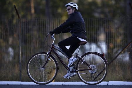 Brazil's President Dilma Rousseff rides her bicycle near the Alvorada Palace in Brasilia, July 27, 2015. REUTERS/Ueslei Marcelino