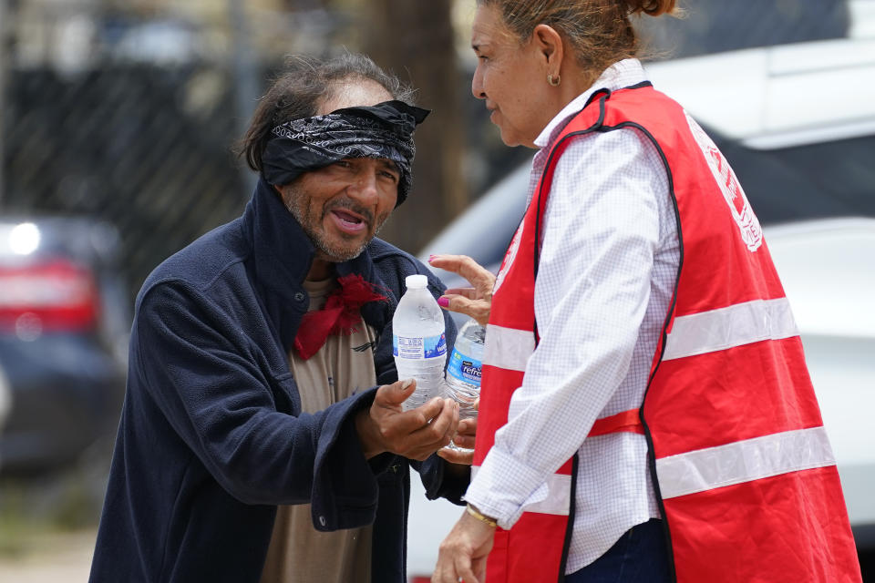 Salvation Army volunteer Francisca Corral gives water to a man at their Valley Heat Relief Station, Tuesday, July 11, 2023 in Phoenix. Even desert residents accustomed to scorching summers are feeling the grip of an extreme heat wave smacking the Southwest this week. Arizona, Nevada, New Mexico and Southern California are getting hit with 100-degree-plus Fahrenheit temps and excessive heat warnings. (AP Photo/Matt York)