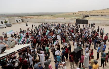 Displaced Syrians gather during a protest calling for an end to the strikes and for Ankara to open the frontier at the Atmeh crossing on the Syrian-Turkish border, in Idlib governorate