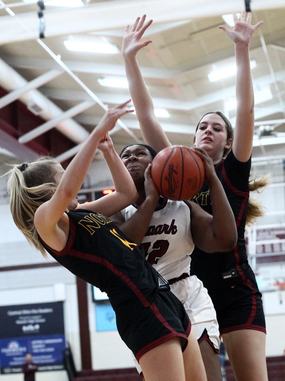 Newark senior Syncere Royster finds herself sandwiched between Westerville North defenders Kayleigh Hilderbrand, left, and Chloe Shockley on Tuesday, Dec. 20, 2022 at Jimmy Allen Gymnasium. The host Wildcats fell 56-49.