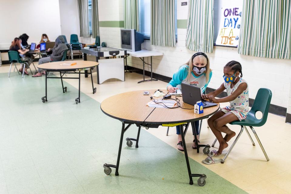 Jayne Harbin-Pettit, left, helps a shelter resident with her online school work at Unity House, a Volunteers for America shelter for families in Louisville. May 15, 2020
