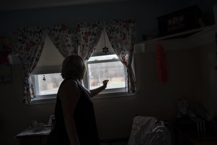 Susan Ryder raises the blinds in the room of her mother, Betty Bednarowski, Tuesday morning, Nov. 30, 2021, in Rotterdam Junction, N.Y. (AP Photo/Wong Maye-E)