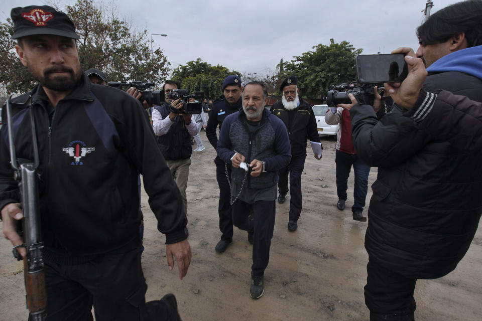 Pakistani police officers escort to Piran Ditta Khan, center, who has been arrested in the killing of a British woman police officer, following his court appearance in Islamabad, Pakistan, Wednesday, Jan. 29, 2020. Khan, who was taken in custody earlier this week, appeared before a court in Islamabad over an extradition request from Britain. His arrests was the result of close cooperation between Pakistani authorities and British detectives, police said. Khan was remanded in custody and is due back in court mid in January. (AP Photo/Anjum Naveed)