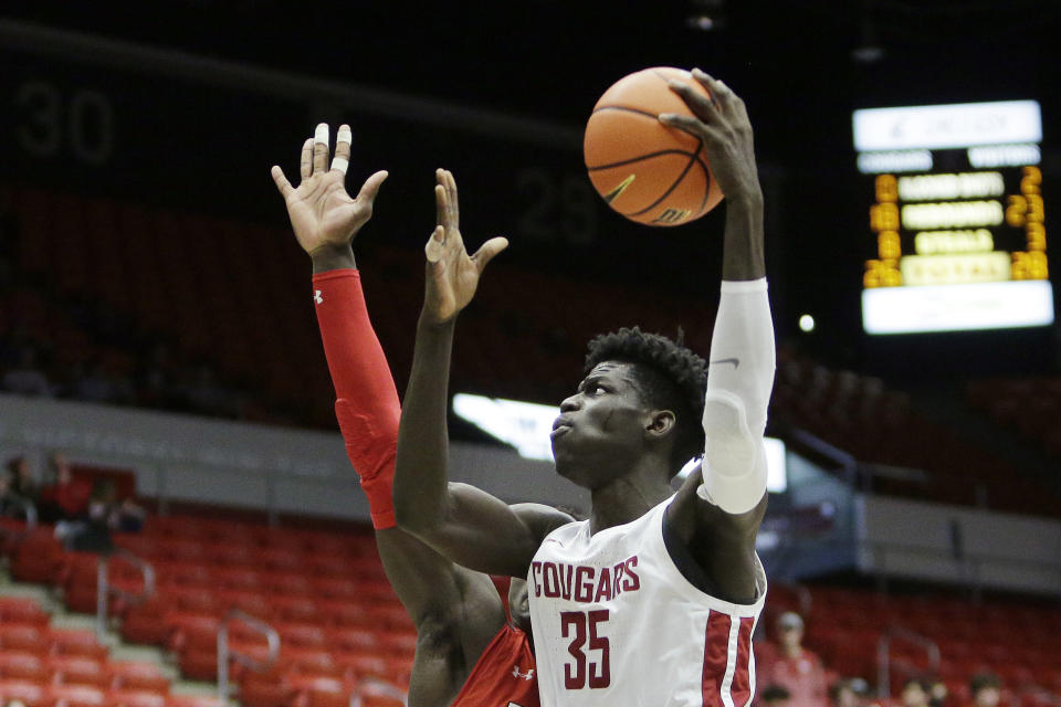 Washington State forward Mouhamed Gueye, right, shoots while defended by Utah center Keba Keita during the second half of an NCAA college basketball game, Sunday, Dec. 4, 2022, in Pullman, Wash. Utah won 67-65. (AP Photo/Young Kwak)