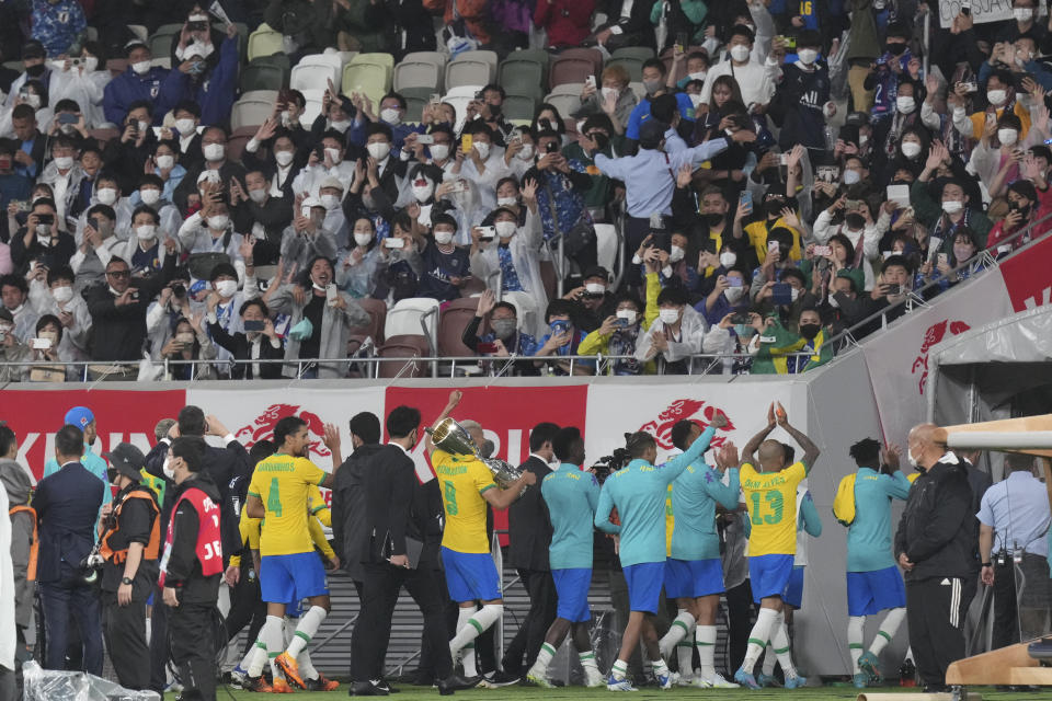 Brazil soccer team members waves to Japanese fans after a friendly match with Japan's team at the National Stadium in Tokyo Monday, June 6, 2022. (AP Photo/Eugene Hoshiko)