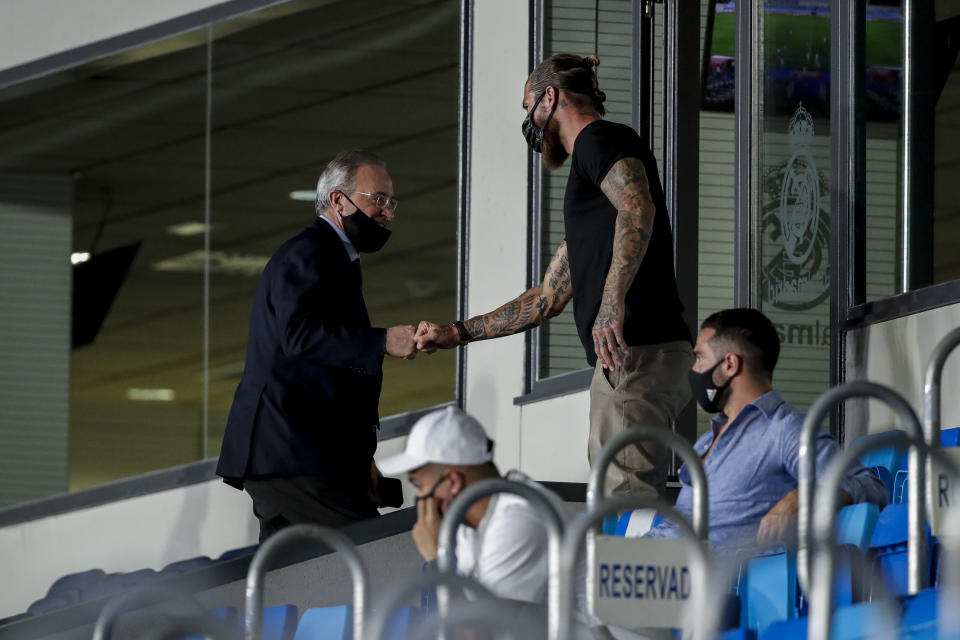 Sergio Ramos y Florentino Pérez dándose la mano en una grada.