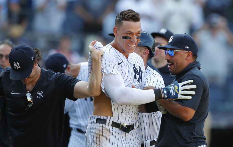 New York Yankees' Aaron Judge, center, and starting pitcher Nestor Cortes, right, celebrate after defeating the Houston Astros in the 10th inning of a baseball game, Sunday, June 26, 2022, in New York. (AP Photo/Noah K. Murray)