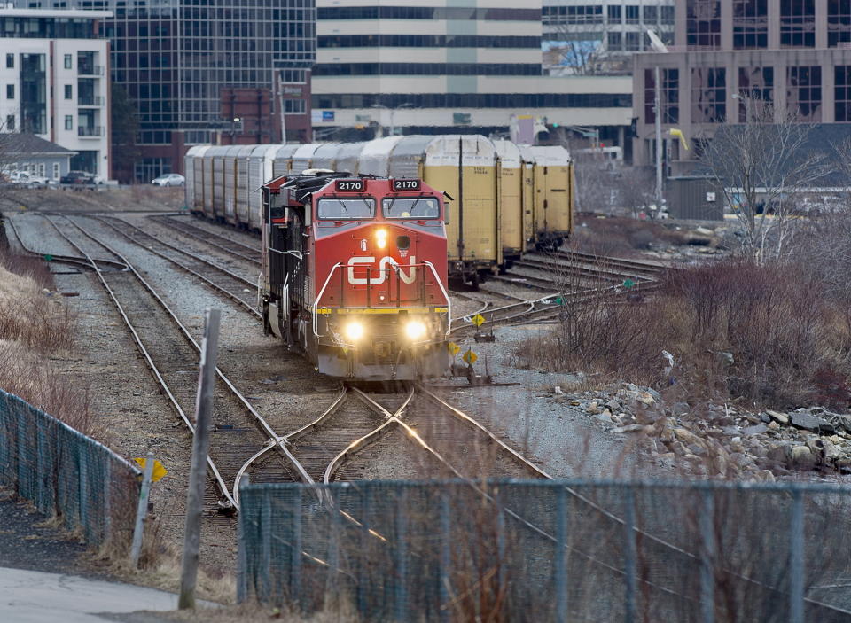 FILE - In this March 29, 2018 file photo, a Canadian National Rail locomotive moves through the rail yard in Dartmouth, Nova Scotia. The railroad merger that was nearly derailed by a bidding war earlier this year is moving forward although regulators will have the final say next year on Canadian Pacific’s $31 billion acquisition of Kansas City Southern railroad. Canadian Pacific set up a voting trust that purchased Kansas City Southern Tuesday, Dec. 14, 2021, after shareholders of both railroads overwhelmingly approved the deal last week. (Andrew Vaughan/The Canadian Press via AP)