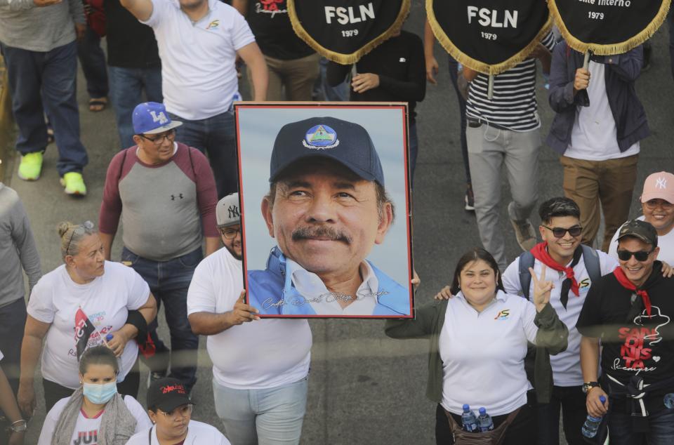 A man marches holding a portrait of President Daniel Ortega during a pro-government march in Managua, Nicaragua, Saturday, Feb. 11, 2023. (AP Photo)