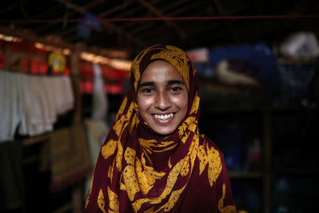 Formin Akter, a Rohingya refugee girl, smiles as she poses for a picture before heading to Chittagong to attend school at the Asian University for Women, in Cox's Bazar, Bangladesh, August 24, 2018. Picture taken August 24, 2018. REUTERS/Mohammad Ponir Hossain