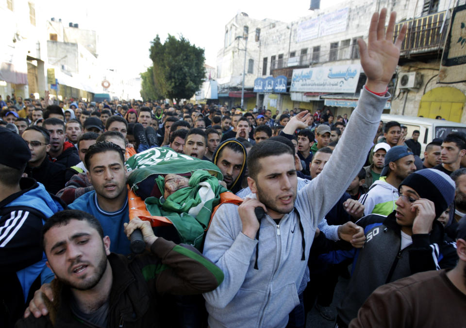 Palestinians carry the body of Hamza Abu el-Heija, who was killed in a raid by Israeli troops, during his funeral procession, in the West Bank refugee camp of Jenin, Saturday, March 22, 2014. Israeli troops killed at least four Palestinians in an early morning raid that was followed by a clash with angry protesters in a West Bank town on Saturday, the Israeli military and Palestinian security officials said, in the deadliest incident in months. The Israeli military said the raid aimed to arrest Hamza Abu el-Heija, a 22-year-old Hamas operative wanted for involvement in shooting and bombing attacks against Israelis. (AP Photo/Mohammed Ballas)