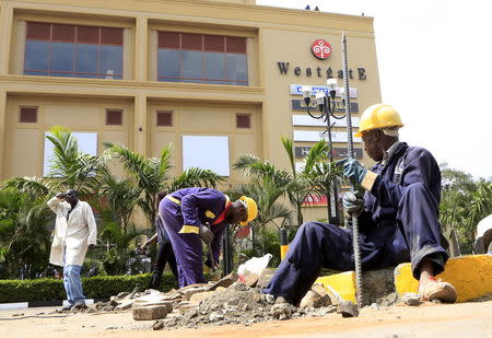 Construction workers dig holes to erect barriers at the reopened Westgate shopping mall, which was closed in the aftermath of an attack by militant gunmen in September 2013 that killed 67 people and injured many more, in capital Nairobi July 14, 2015. REUTERS/Noor Khamis