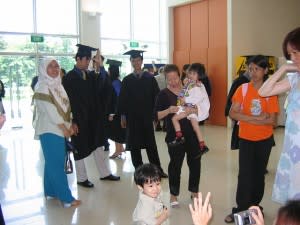 Singapore graduates, one man fiddling with his cap