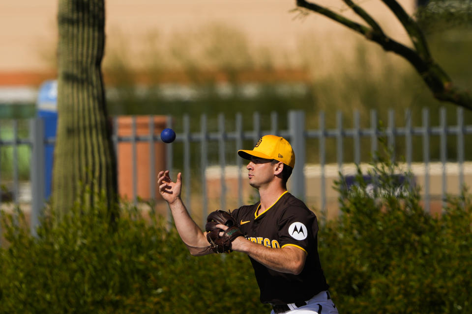 FILE - San Diego Padres pitcher Matt Festa warms up with a weighted ball during spring training baseball workouts Feb. 18, 2024, in Peoria, Ariz. Velocity training is the rage in baseball from the youth levels up through the majors. Players go through specialized programs – often using series of progressively weighted baseballs – in the hopes of speeding up their bodies and arms, pushing them to the limits of what might be possible for their age and ability. (AP Photo/Lindsey Wasson, File)