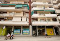 People walk past branches of Bankia and Caixabank in Barcelona