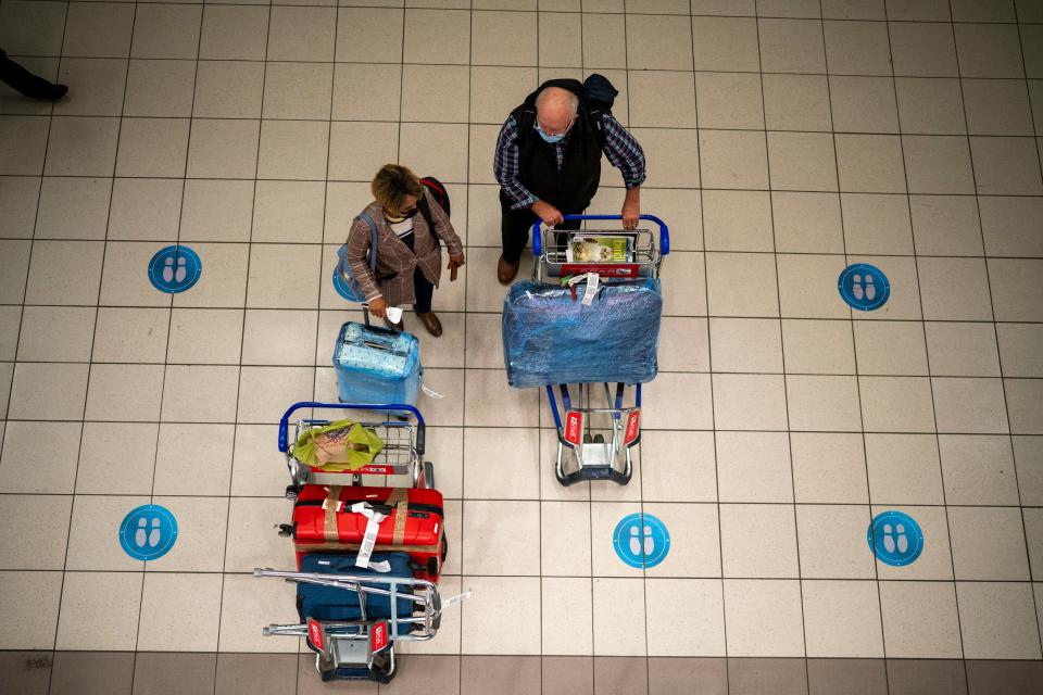 People wait at OR Tambo's airport in Johannesburg, South Africa', Friday Nov. 26, 2021. A slew of nations moved to stop air travel from southern Africa on Friday in reaction to news of a new, potentially more transmissible COVID-19 variant that has been detected in South Africa. Scientists say it is a concern because of its high number of mutations and rapid spread among young people in Gauteng, the country's most populous province.