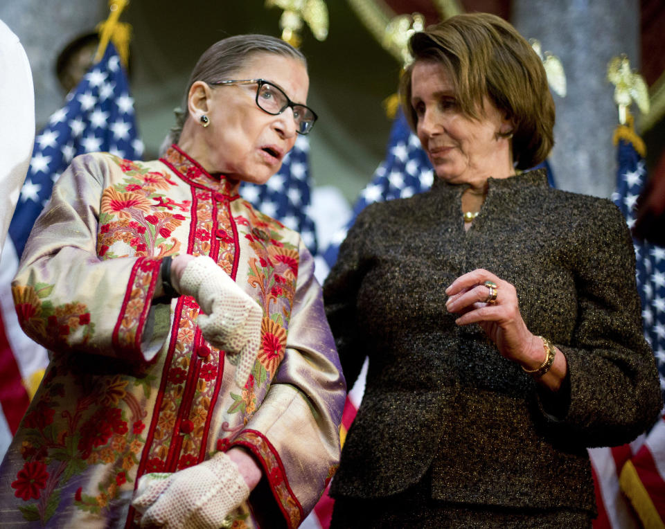 FILE - House Minority Leader Nancy Pelosi of Calif., right, talks with Supreme Court, Associate Justice Ruth Bader Ginsburg during her annual Women's History Month reception, March 18, 2015, on Capitol Hill in Washington. A collection of nearly 100 items is being sold in an online auction that begins Wednesday, Sept. 7, 2022, and runs through Sept. 16, including a pair of cream-colored gloves owned by Ginsburg, not the pair shown above. It concludes just before the two-year anniversary of Ginsburg's death at 87. The proceeds will benefit SOS Children’s Villages, an organization that supports vulnerable children around the world. (AP Photo/Pablo Martinez Monsivais, File)