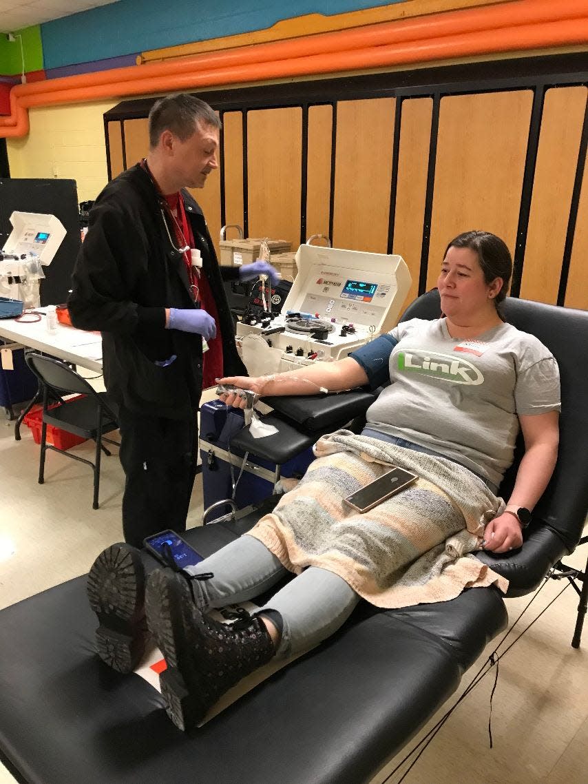 Misty Grantham, 41, of Monroe donates a double unit of red blood cells for the first time during an American Red Cross blood drive at Custer Elementary School 1 Monday afternoon. 
A Power Red donation, as it is called, uses an automated process that separates red blood cells from other blood components, then safely returns the donor’s plasma and platelets back to them. Red blood cells are the most commonly transfused blood component, and therefore the most needed. Red cells carry oxygen throughout the body and help trauma and surgery patients, those undergoing organ transplants, women experiencing complications from childbirth and people with anemia. Grantham, 41, has A-positive blood and has donated regular, whole blood cells for the past 14 years. Assisting her is Ken Szych, a collection technician 1 for the Red Cross. 
Grantham brought along her daughter, Kara, 15, who will be eligible to donate when she turns 16. Grantham was one of 36 people who pre-registered to donate whole blood or red cells at the five-hour drive. Employed by Link Real Estate Co. in Monroe, she recalled receiving a blood transfusion before giving birth to her daughter.