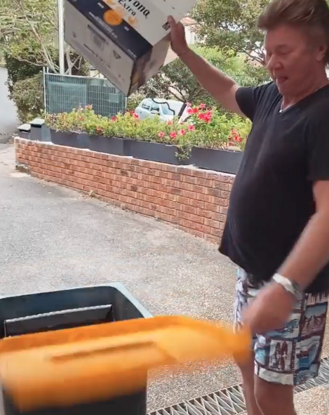 Richard Wilkins places Corona beer carton in recycling bin