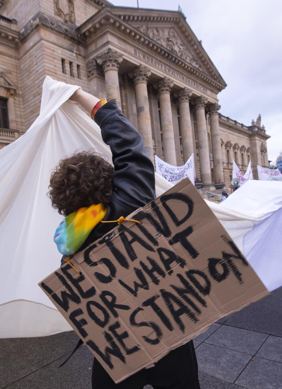 A demonstrator holds a white cloth as a symbol of a fresh start in the climate politics during a protest climate strike ralley of the 'Friday For Future Movement' in front of the Federal Administrative Court building in Leipzig, Germany, Friday, Nov. 29, 2019. Cities all over the world have strikes and demonstrations for the climate during this ClimateActionDay. (AP Photo/Jens Meyer)