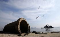 A pipe is seen near a fishing boat on Fundao beach in the Guanabara Bay in Rio de Janeiro March 13, 2014. According local media, the city of Rio de Janeiro continues to face criticism locally and abroad that the bodies of water it plans to use for competition in the 2016 Olympic Games are too polluted to host events. Untreated sewage and trash frequently find their way into the Atlantic waters of Copacabana Beach and Guanabara Bay - both future sites to events such as marathon swimming, sailing and triathlon events. REUTERS/Sergio Moraes (BRAZIL - Tags: ENVIRONMENT SPORT OLYMPICS)