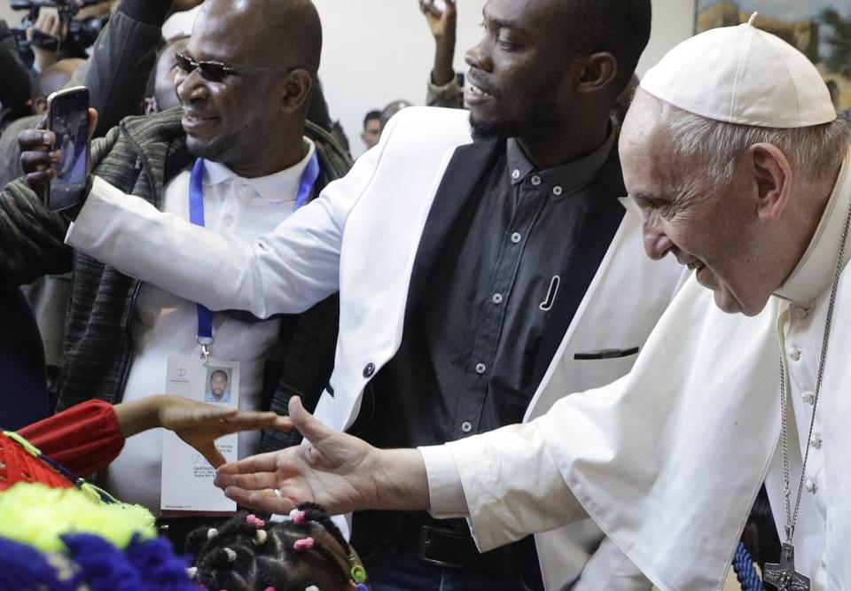 Pope Francis reaches for the hand of a child during a visit to the diocesan Caritas center in Rabat, Morocco, Saturday, March 30, 2019. Francis's weekend trip to Morocco aims to highlight the North African nation's tradition of Christian-Muslim ties while also letting him show solidarity with migrants at Europe's door and tend to a tiny Catholic flock on the peripheries. (AP Photo/Gregorio Borgia)