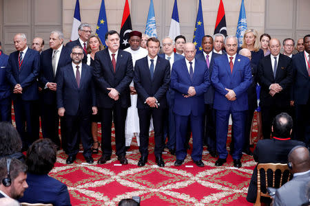 French President Emmanuel Macron, Libyan Prime Minister Fayez al-Sarraj, Khalifa Haftar, the military commander who dominates eastern Libya, and the participants of the International Conference on Libya listen to a verbal agreement between the various parties regarding the organization of a democratic election this year at the Elysee Palace in Paris, France, May 29, 2018. Etienne Laurent/Pool via Reuters