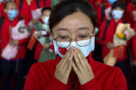 FILE - In this April 8, 2020, file photo, a medical worker from China's Jilin Province reacts as she prepares to return home at Wuhan Tianhe International Airport in Wuhan in central China's Hubei Province. The Chinese city of Wuhan is looking back on a year since it was placed under a 76-day lockdown beginning Jan. 23, 2020. (AP Photo/Ng Han Guan, File)