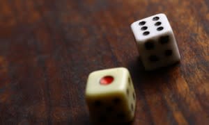 Two dice displaying on a wooden surface